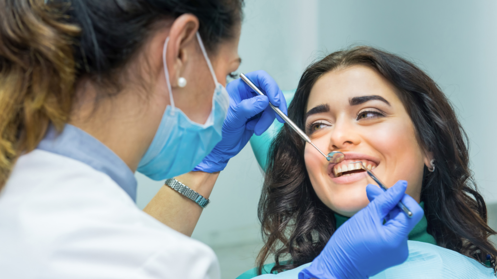 Dentist examining a patient’s teeth during a smile makeover consultation.